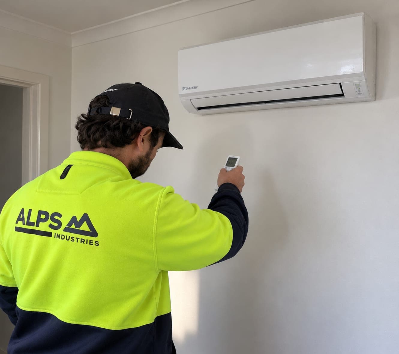 Alps Industries technician installing a wall-mounted split system